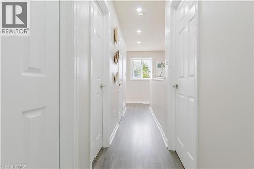 Hallway featuring recessed lighting, wood-finish flooring, white paneled doors, and a window - 67 Kinzie Avenue, Kitchener, ON - Indoor Photo Showing Other Room