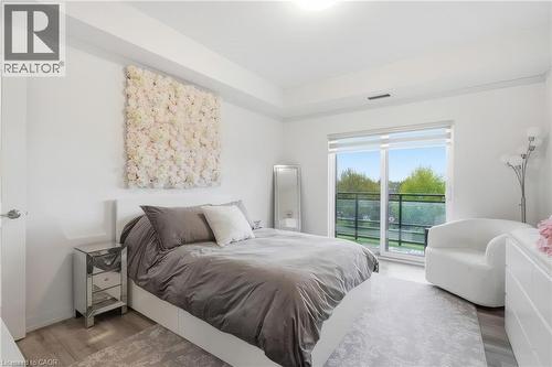 Slider door to outdoor balcony, wood-finish flooring, recessed lighting, and high ceilings - 251 Northfield Drive E Unit# 312, Waterloo, ON 