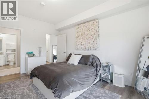Light wood-finish flooring with white walls and trim, featuring a partial bathroom entry - 251 Northfield Drive E Unit# 312, Waterloo, ON 