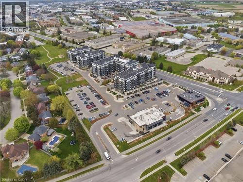 Contemporary residential buildings with multiple stories, ample on-site parking, and surrounding commercial structures - 251 Northfield Drive E Unit# 312, Waterloo, ON 