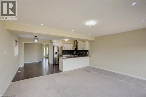 Open-concept kitchen featuring stainless steel appliances, white cabinetry, dark subway tile backsplash, and a breakfast bar - 193 Mccann Street, Guelph, ON - Indoor Photo Showing Kitchen