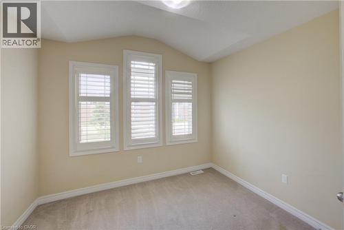 Vaulted ceiling, three windows with white plantation shutters, neutral wall color, and carpet flooring - 193 Mccann Street, Guelph, ON - Indoor Photo Showing Other Room