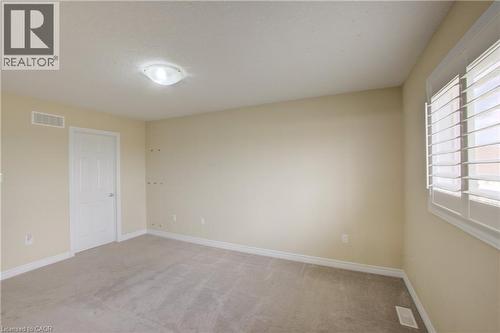 Neutral tone wall color, wall-to-wall carpeting, window with plantation shutters, white interior door, flush mount ceiling light - 193 Mccann Street, Guelph, ON - Indoor Photo Showing Other Room