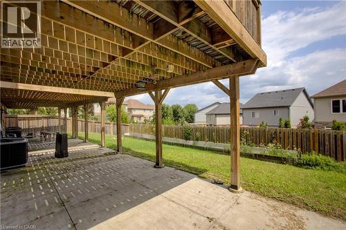 Expansive outdoor space featuring a covered concrete patio, wood fencing, and a grassy area - 193 Mccann Street, Guelph, ON - Outdoor With Deck Patio Veranda