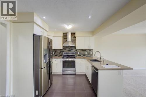 Kitchen featuring stainless steel appliances, light cabinetry, a mosaic tile backsplash, a peninsula with an undermount sink, and recessed lighting - 193 Mccann Street, Guelph, ON - Indoor Photo Showing Kitchen With Double Sink With Upgraded Kitchen