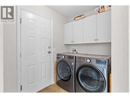 Main floor laundry and entrance to garage. - 4400 Gallaghers Drive E Unit# 2, Kelowna, BC - Indoor Photo Showing Laundry Room