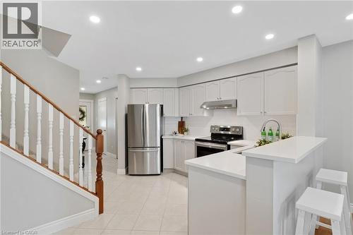 Modern kitchen featuring white cabinetry, stainless steel appliances, tile flooring, and recessed lighting - 711 Angler Way, Waterloo, ON - Indoor Photo Showing Kitchen With Upgraded Kitchen
