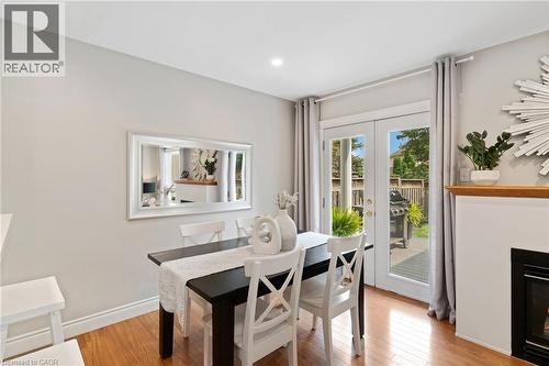 Hardwood-finish flooring, recessed lighting, and a fireplace with a wood mantle - 711 Angler Way, Waterloo, ON - Indoor Photo Showing Dining Room With Fireplace