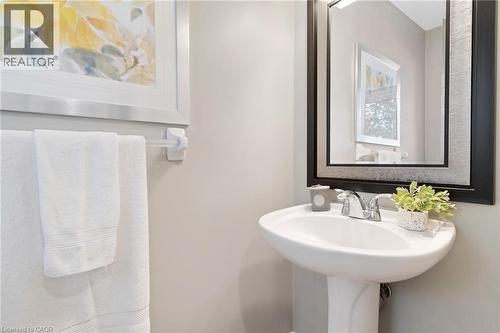 Pedestal sink with chrome-finish faucet, framed mirror, and light-toned wall paint - 711 Angler Way, Waterloo, ON - Indoor Photo Showing Bathroom