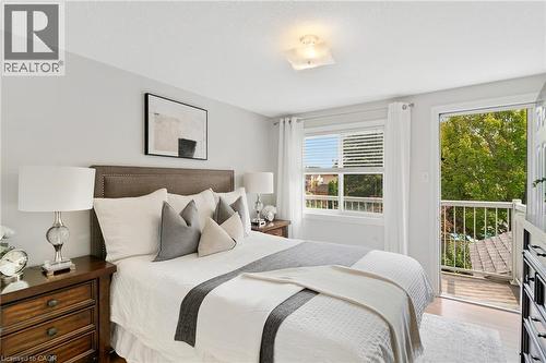 Hardwood-finish flooring, a contemporary ceiling light fixture, and an exterior balcony with white railings - 711 Angler Way, Waterloo, ON - Indoor Photo Showing Bedroom