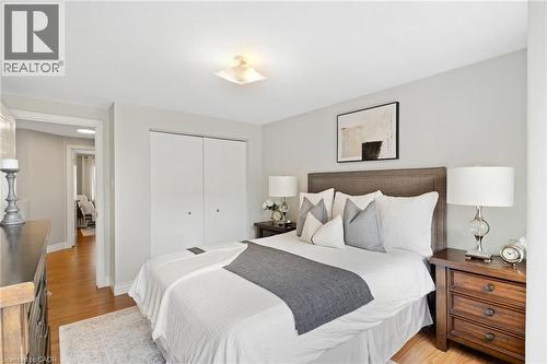 Wood-finish flooring, light gray wall paint, and a built-in closet with bi-fold doors - 711 Angler Way, Waterloo, ON - Indoor Photo Showing Bedroom