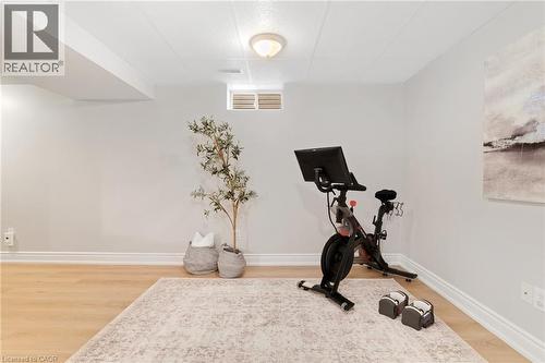 Wood-finish flooring, drop ceiling with recessed lighting, and a window - 711 Angler Way, Waterloo, ON - Indoor Photo Showing Gym Room