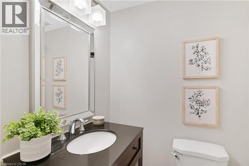 Vanity with an integrated oval sink, chrome faucet, and dark countertop - 711 Angler Way, Waterloo, ON - Indoor Photo Showing Bathroom