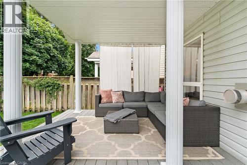 Covered patio featuring a slatted ceiling, white support columns, and wood-finish decking - 711 Angler Way, Waterloo, ON - Outdoor With Exterior