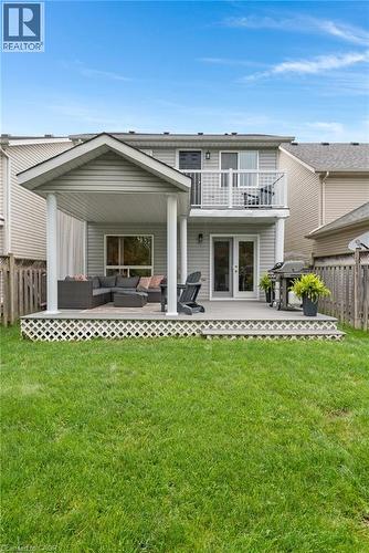 Expansive backyard featuring a manicured lawn, a covered patio, an open-air deck, and an upper-level balcony - 711 Angler Way, Waterloo, ON - Outdoor