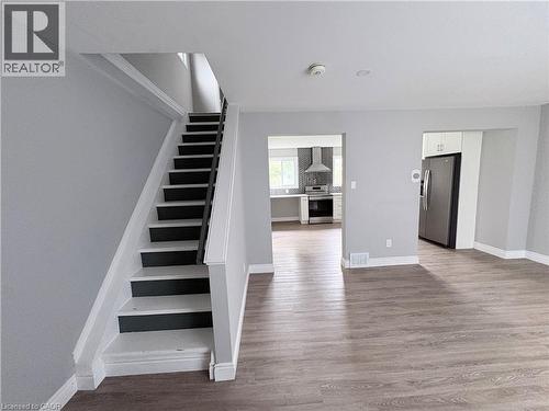 Wood-finish flooring throughout, with a staircase featuring contrasting risers and treads - 216 Brunswick Crescent, London, ON - Indoor Photo Showing Other Room