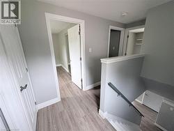 Wood-finish flooring throughout, with white trim and doors - 