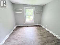 Neutral gray wall color, wood-finish flooring, white window trim, and two built-in floating shelves - 