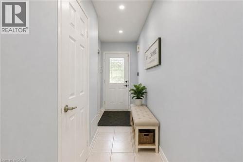 Recessed lighting illuminates the entryway featuring a six-panel door with brushed nickel hardware, and tiled flooring - 1793 Creek Way, Burlington, ON - Indoor Photo Showing Other Room