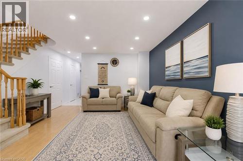 Open-concept living area featuring recessed lighting, wood-finish flooring, and a staircase with wood railings - 1793 Creek Way, Burlington, ON - Indoor Photo Showing Living Room