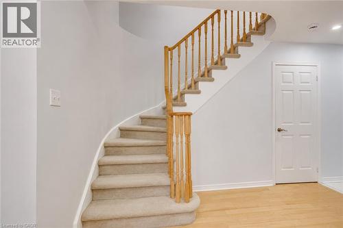 Curved staircase with carpeted treads, wood handrails, and balusters - 1793 Creek Way, Burlington, ON - Indoor Photo Showing Other Room