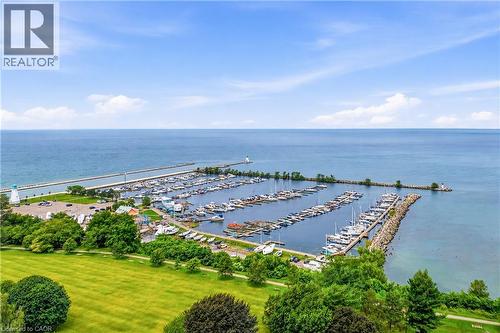 Expansive waterfront setting featuring a marina with numerous boat slips, a tranquil body of water, and a tree-lined shoreline - 11 Kimbermount Drive, St. Catharines, ON - Outdoor With Body Of Water With View