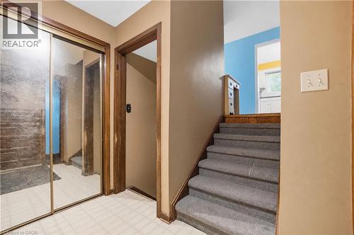 Carpeted staircase with wood-finish trim and a mirrored closet door - 11 Kimbermount Drive, St. Catharines, ON - Indoor Photo Showing Other Room
