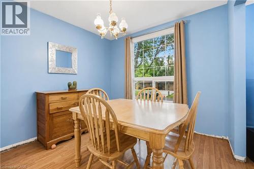 Dining area featuring wood-finish flooring, a double-paned window, and a decorative chandelier - 11 Kimbermount Drive, St. Catharines, ON - Indoor Photo Showing Dining Room