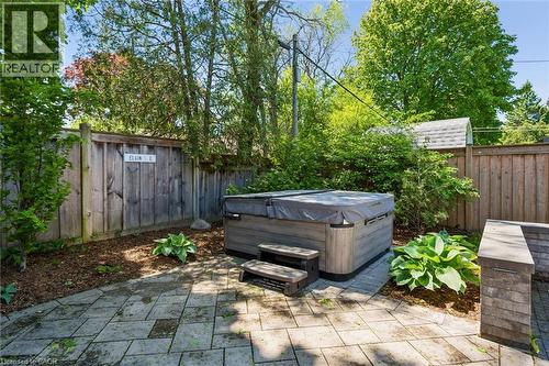 Patio with paver stone surface, built-in hot tub, and wood fencing - 90 Dean Avenue, Guelph, ON - Outdoor