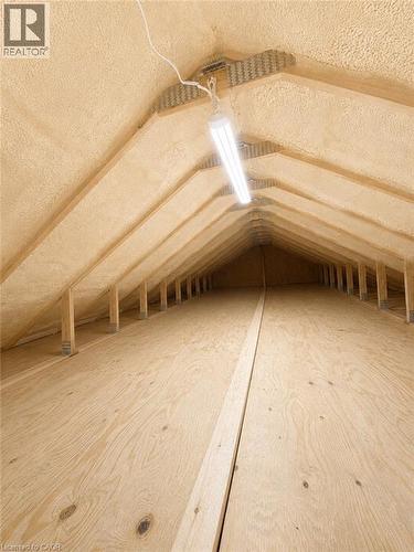 Attic space featuring spray foam insulation, exposed wood rafters, and wood-finish flooring - 90 Dean Avenue, Guelph, ON - Indoor Photo Showing Other Room
