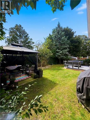 Expansive green lawn with a patio area and a separate wooden deck - 512 Hawthorne Crescent, Milton, ON - Outdoor
