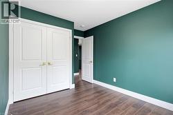 Wood-finish flooring, white paneled doors with brass hardware, and painted walls - 