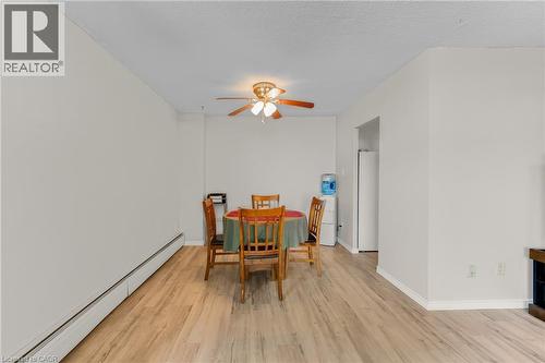 Wood-finish flooring throughout, ceiling fan with integrated lighting, and neutral wall tones - 975 Warwick Court Unit# 708, Burlington, ON - Indoor Photo Showing Dining Room