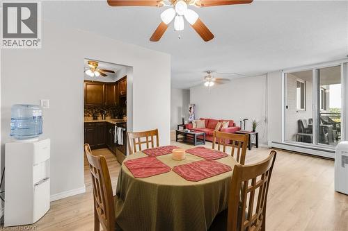 Wood-finish flooring throughout, bright white walls, and a ceiling fan with integrated lighting - 975 Warwick Court Unit# 708, Burlington, ON - Indoor Photo Showing Dining Room