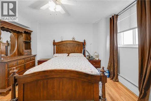 Wood-finish flooring, ceiling fan, and window with horizontal blinds - 975 Warwick Court Unit# 708, Burlington, ON - Indoor Photo Showing Bedroom