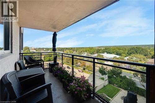 Balcony featuring a glass panel railing, concrete flooring, and a painted ceiling - 975 Warwick Court Unit# 708, Burlington, ON - Outdoor With Balcony With View With Exterior