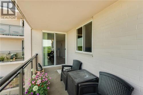 Outdoor balcony with concrete flooring, glass railing, sliding patio door, and a permanent window - 975 Warwick Court Unit# 708, Burlington, ON - Outdoor With Exterior