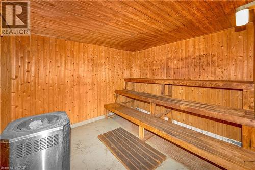 Sauna featuring wood paneling, multi-tiered wood bench seating, and a metallic sauna heater - 975 Warwick Court Unit# 708, Burlington, ON - Indoor Photo Showing Other Room