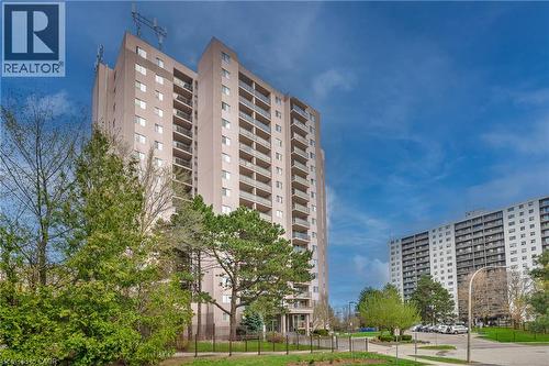 Multi-story building featuring individual balconies, a flat roof, and a structured entry canopy - 975 Warwick Court Unit# 708, Burlington, ON - Outdoor With Balcony With Facade