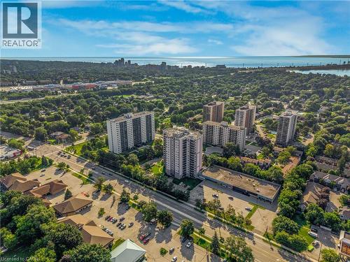 Expansive urban landscape featuring multiple high-rise buildings, mature tree canopy, and distant water views - 975 Warwick Court Unit# 708, Burlington, ON - Outdoor With View