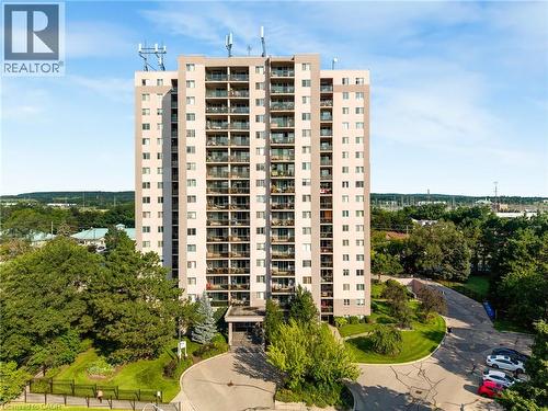 Multi-story residential building with private balconies and a paved entry drive - 975 Warwick Court Unit# 708, Burlington, ON - Outdoor With Facade