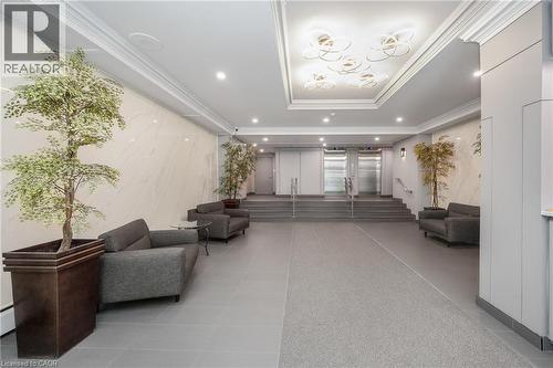 Recessed lighting, crown molding, marble-patterned wall panels, stainless steel elevators, and gray tile flooring - 975 Warwick Court Unit# 708, Burlington, ON - Indoor Photo Showing Other Room