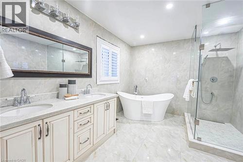Bathroom featuring a freestanding soaking tub, frameless glass shower with rain showerhead, dual vanity with undermount sinks, and a large framed mirror - 247 Sand Road, Holland Landing, ON - Indoor Photo Showing Bathroom