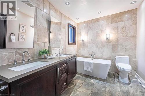 Contemporary bathroom featuring a freestanding tub and a dual-sink vanity with dark wood cabinetry and integrated sinks - 247 Sand Road, Holland Landing, ON - Indoor Photo Showing Bathroom