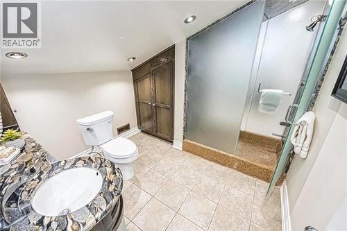 Bathroom featuring a vanity with an integrated sink and mosaic stone countertop, a white toilet, and a shower enclosure with frosted glass panels and a stone base - 247 Sand Road, Holland Landing, ON - Indoor Photo Showing Bathroom