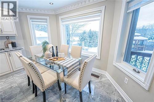 Bay window dining area with natural light, featuring tiled flooring, crown molding, and built-in cabinetry with stone countertops - 247 Sand Road, Holland Landing, ON - Indoor Photo Showing Dining Room