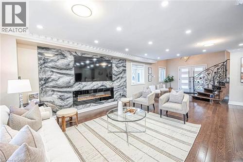 Spacious living area featuring a large stone accent wall with an integrated fireplace, recessed lighting, crown molding, and wood-finish flooring - 247 Sand Road, Holland Landing, ON - Indoor Photo Showing Living Room With Fireplace