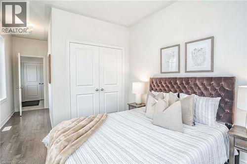 Wood-finish flooring throughout, white walls, and a double-door closet with paneling - 525 Red Elm Road, Shelburne, ON - Indoor Photo Showing Bedroom