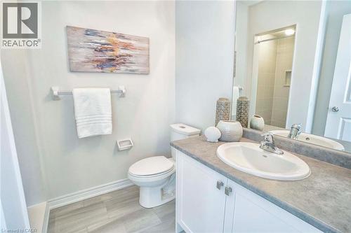 White vanity with cabinet storage, integrated sink, and gray countertop - 525 Red Elm Road, Shelburne, ON - Indoor Photo Showing Bathroom