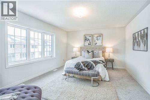 Bright room featuring a large window, neutral carpeting, and a ceiling-mounted light fixture - 525 Red Elm Road, Shelburne, ON - Indoor Photo Showing Bedroom